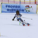 un giovanissimo sciatore in vista frontale mentre scende sulla neve