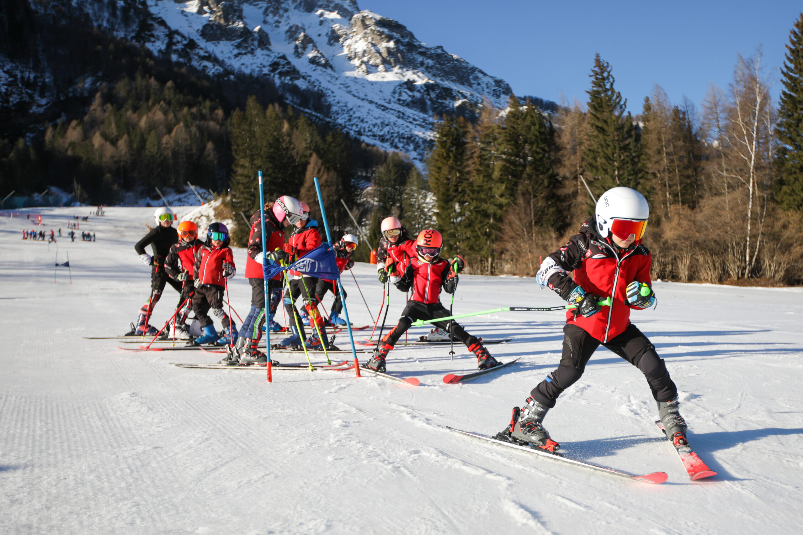 un gruppeto di giovanissimi sciatori mentre scendono dalla pista innevata in fila